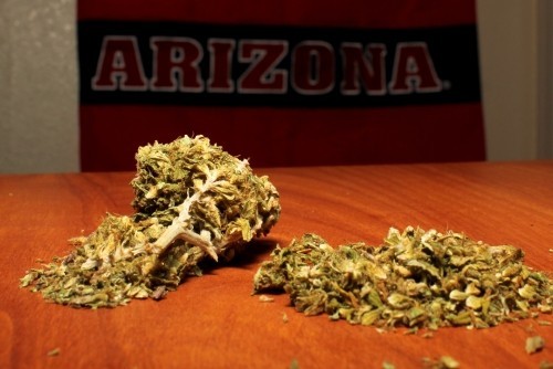 Marijuana on a table in front of a University of Arizona flag.