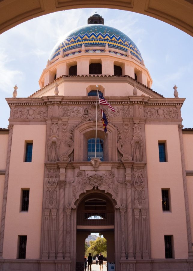 Two people pass under the mosaic dome of the Pima County Historic Courthouse. The sprawling Spanish Colonial building has long been associated with the region, with its dome appearing on the Pima County logo.