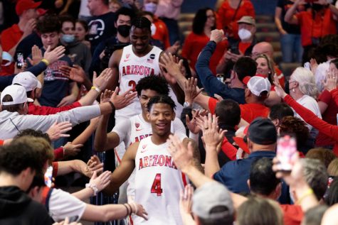 The Arizona men's basketball team celebrates after its win against the University of California, Berkeley, earlier this month, winning it the Pac-12 title and trophy. With the Pac-12 champions banner and trophy, the Wildcats would cut down the basketball net and run through the crowd to memorialize the date in Arizona basketball history. 