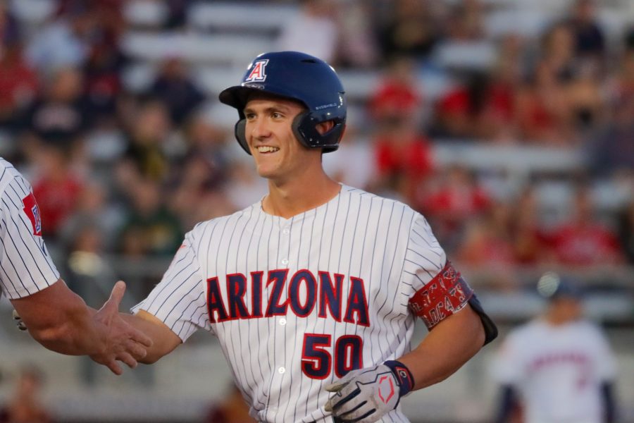 Cameron+Lalinerte+a+catcher+on+the+Arizona+baseball+team+high+fives+his+first+base+coach+after+getting+a+base+hit+on+April+22+at+Hi+Corbett+field.+The+Wildcats+would+win+in+extra+innings+7-6.