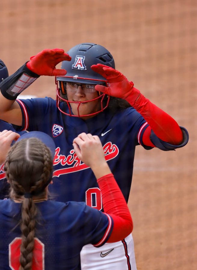 Sophia Carroll an infielder on the Arizona Softball team is greeted by her team at home plate after hitting a two run home run in the bottom of the first on Friday April 15 at Rita Hillenbrand stadium. The wildcats would loose in five innings 11-3.