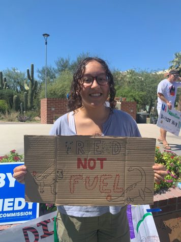 Lexis Meza, a student at the University of Arizona and a UAZ Divest member, holds a sign at a protest to end the use of fossil fuels on Friday, Sept. 23, on the UA Mall. 