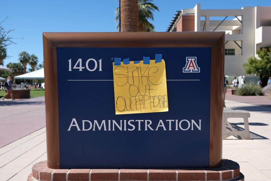 Posters tape up a sign to the Administration building sign at the University of Arizona campus. The protest was a nationwide walkout for the enforcement of Title IX at religious schools. 