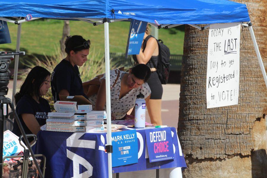 On Monday, Oct. 10, at the University of Arizona, Mission for Arizona employees hand out pizza to those who register to vote. Mission for Arizona supports the Democratic party, showing this with signs supporting U.S. Sen. Mark Kelly.