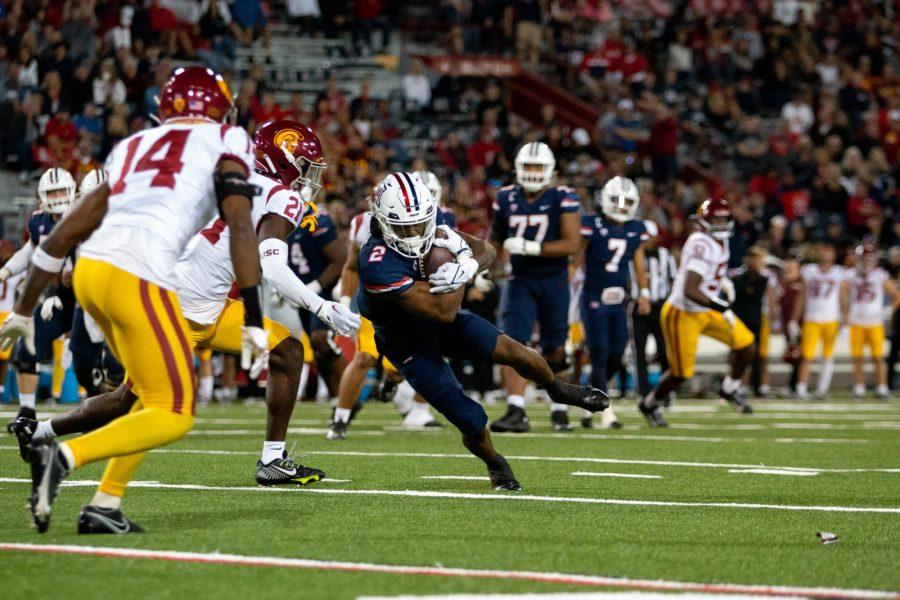 Wide receiver Jacob Cowing (2) runs the ball in a game against USC on Oct. 29 at Arizona Stadium. The Wildcats would go on to lose the game 45-37.