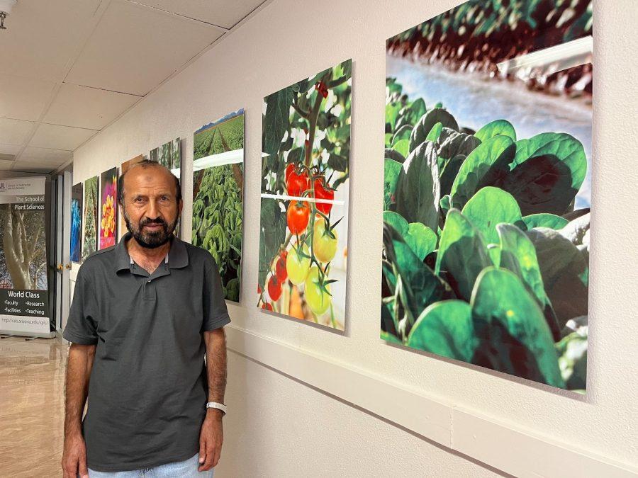 Mohammad Pessarakli stands at a display of photos in the Forbes building on Oct. 7, which represents some of his research done to better cultivate these plants faced with stresses from climate change. 