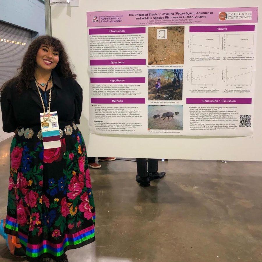 Nadira Mitchell stands next to her presentation on the effects of trash on javelina abundance and wildlife species richness for the University of Arizona’s School of Natural Resources & the Environment. (Courtesy of Nadira Mitchell).