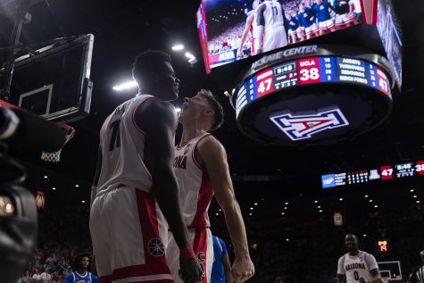 Arizona men’s basketball players Oumar Ballo and Pelle Larsson celebrate scoring against UCLA on Jan. 21 in McKale Center. The Wildcats went on to win with a score of 52-58.