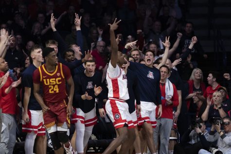The Arizona men’s basketball team celebrates a three-point score from Cedric Henderson on Jan. 19 in McKale Center. The Wildcats went on to win 66-81 against USC.