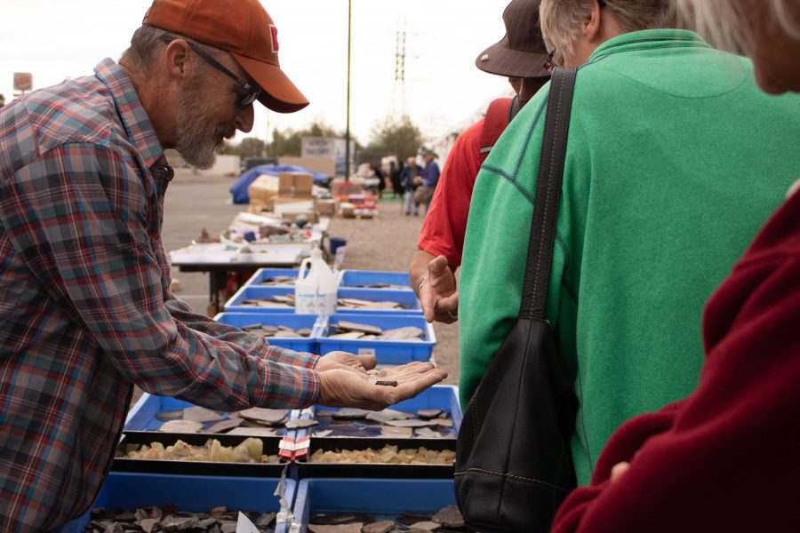 A vendor at the Utah Dump Digger booth shows visitors the rocks and minerals he has on display at the 2023 Tucson Gem, Mineral & Fossil Showcase on Feb. 11. This booth, along with several others, was located near the intersection of North Freeway and West St. Marys Road.