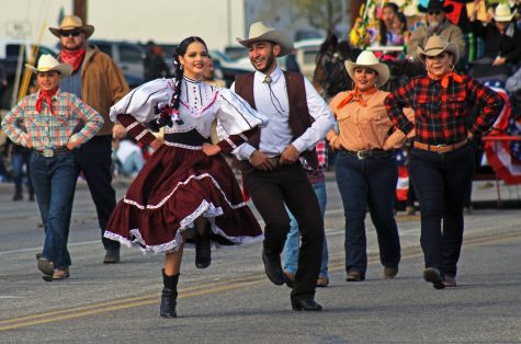Two participants dance together during the annual Tucson Rodeo Parade on Feb. 23 along Ajo Highway. The parade draws more than 200,000 people each year. 