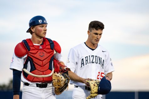 Arizona catcher Tommy Splaine (left) and pitcher TJ Nichols (right) return to the dugout after the top of the first inning in a game against West Virginia on Feb. 24 at Hi Corbett Field. The Wildcats went on to lose the game 6-5. 