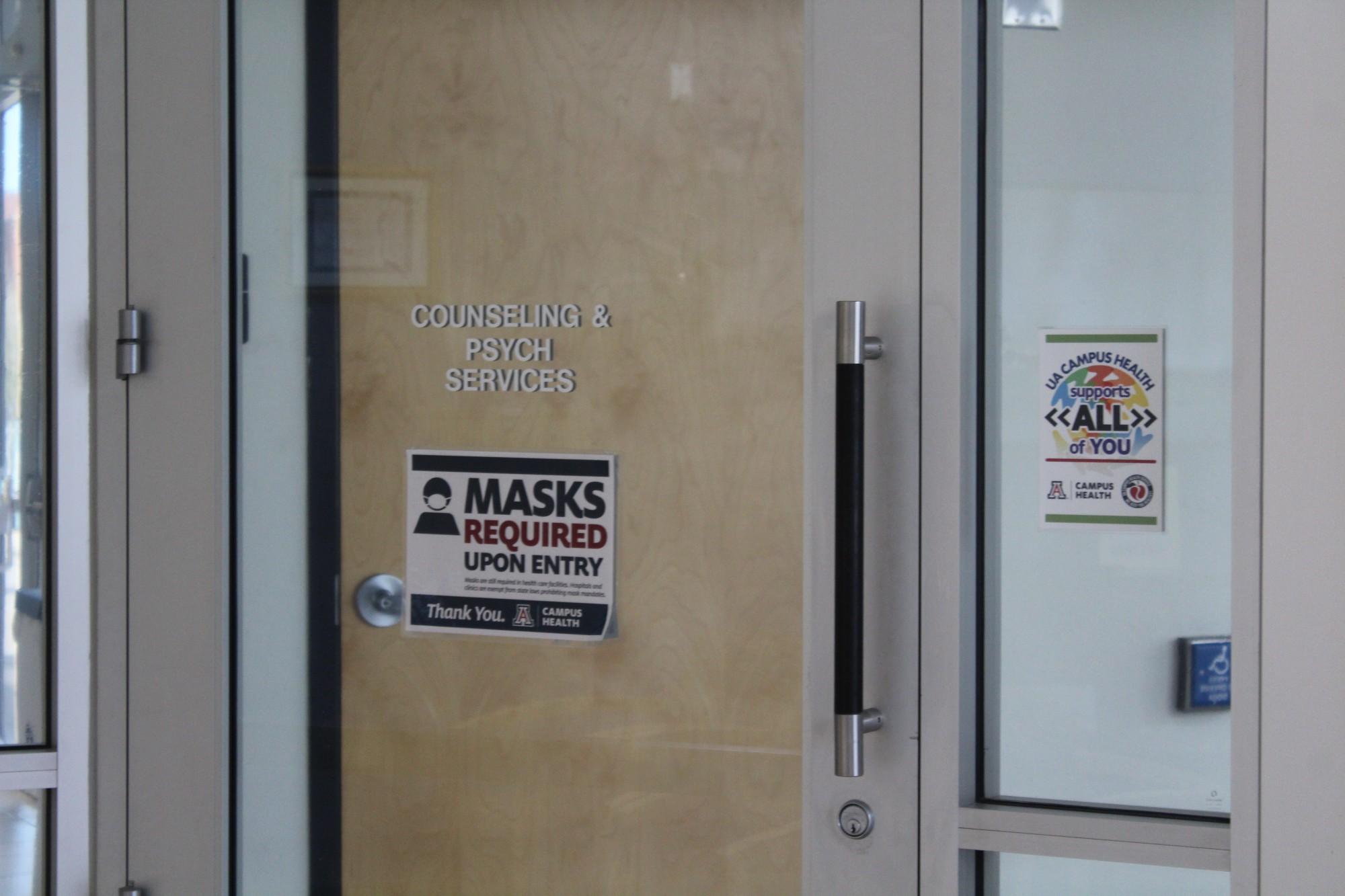 A "Masks Required" sign hangs on the front door to the Counseling and Psych Services office located on the third floor of the Campus Health Center. Masks are still required inorder to attend a CEDAR meeting. 
