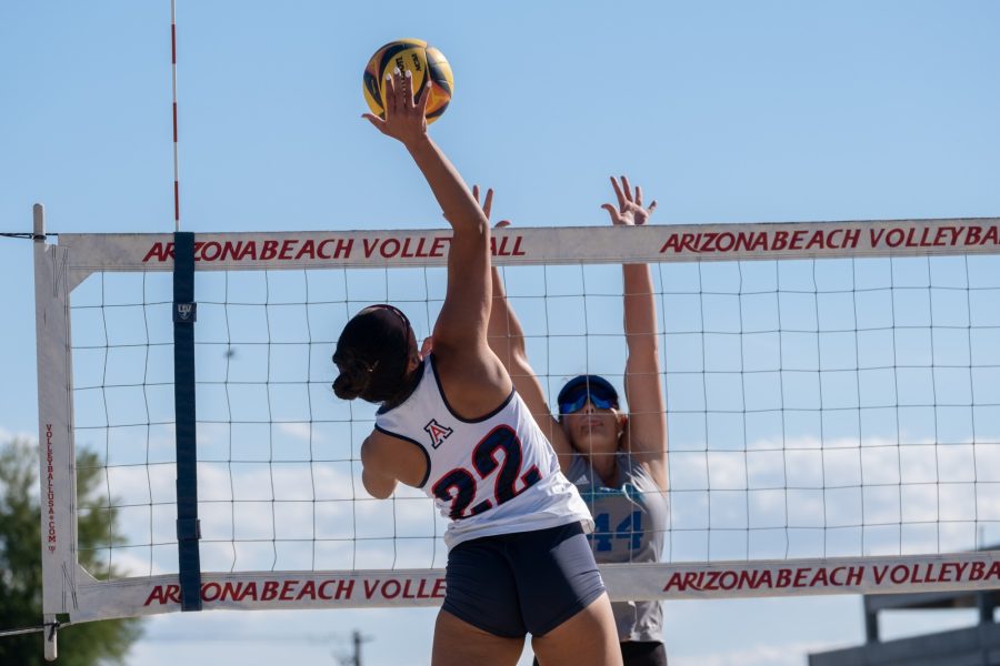 Wildcat senior Hope Shannon (22) attacks the ball above a Texas A&amp;M University-Corpus Christi defense player at Bear Down Beach on March 17. Leaps like these can be some of the most impressive feats that beach volleyball players display during matches.&nbsp;