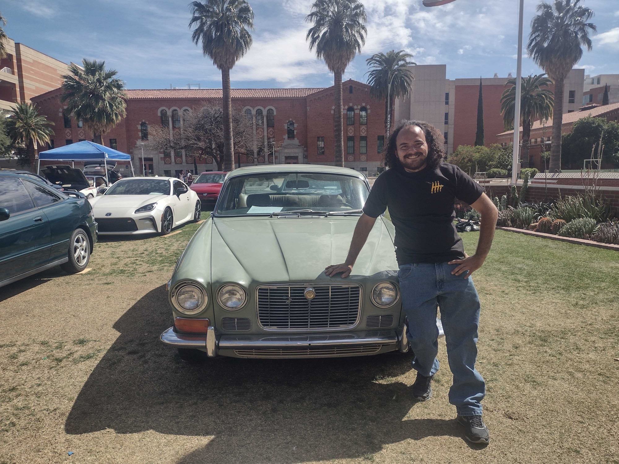 John Gengler, poses with his 1971, Jaguar during the Car Cats show on April, 7, 2023, in Tucson, Ariz. Gengler is president of the Car Cats club and a geosciences major.