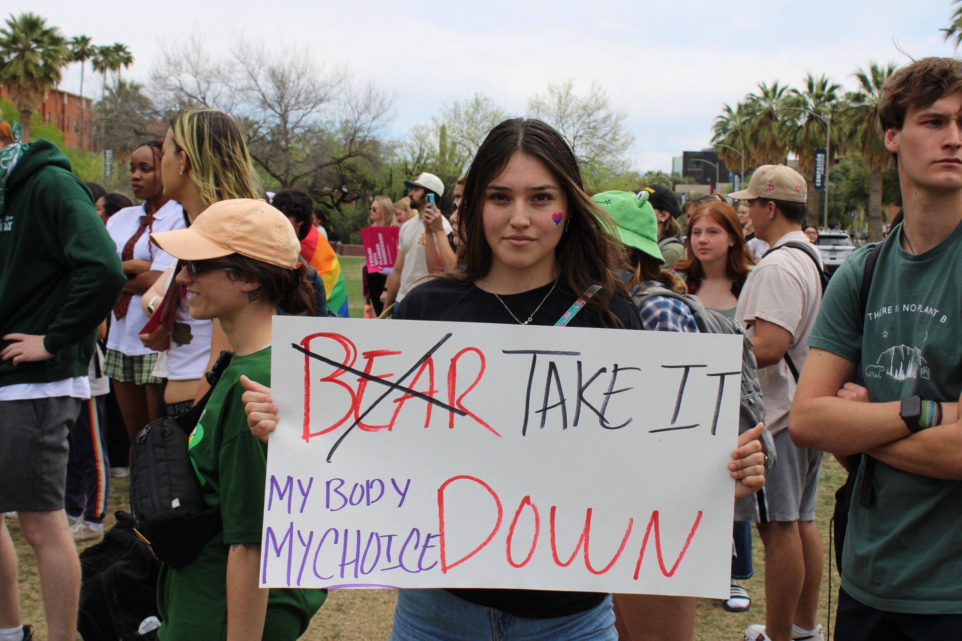 A University of Arizona student and pro-choice supporter holds a sign in protest of the anti-abortion demonstration on display on campus on Thursday, April 13.