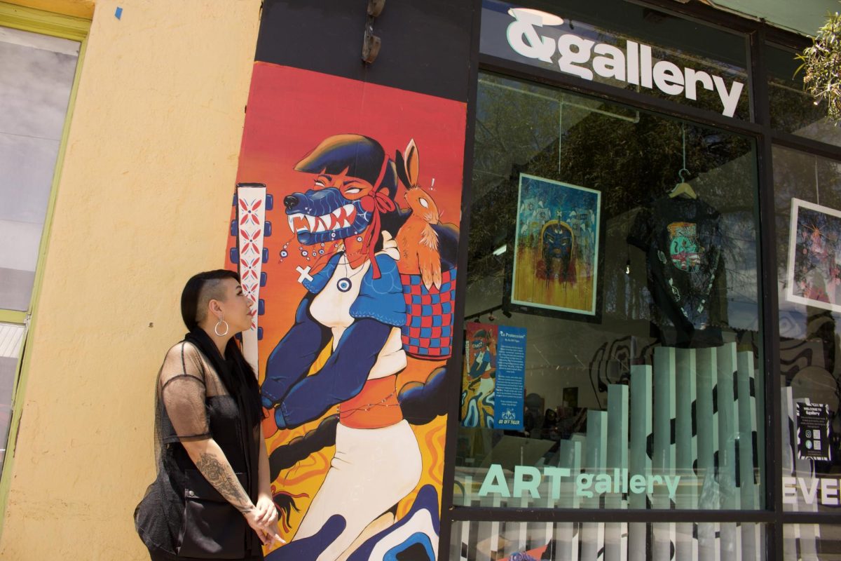 Cynthia Naugle stands in front of her mural at &gallery in Tucson, Ariz. on Aug. 10, 2023. Naugle owns the gallery and is known in the art world as Go Off Tiger.