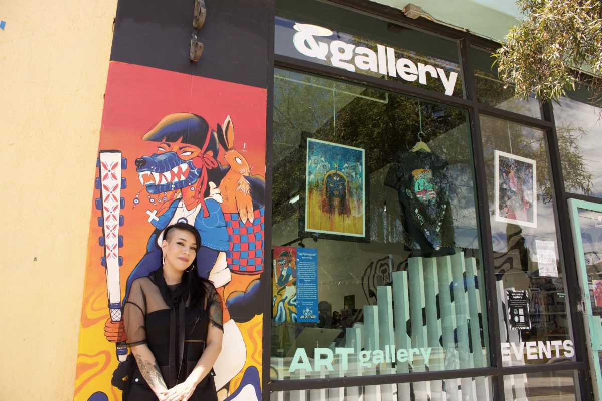 Cynthia Naugle stands in front of her mural at &gallery in Tucson, Ariz. on Aug. 10, 2023. Naugle owns the gallery and is known in the art world as Go Off Tiger.