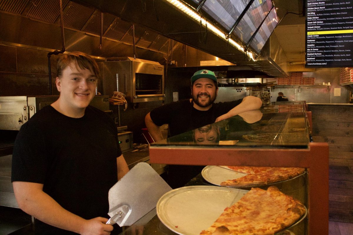 Seamus McCarthy (left) and Lucas Gonzales (right) smile behind the counter at No Anchovies in Tucson, Ariz. on Aug. 15, 2023. The pizza restaurant is located on University Blvd. between Main Gate Square and Frog & Firkin.