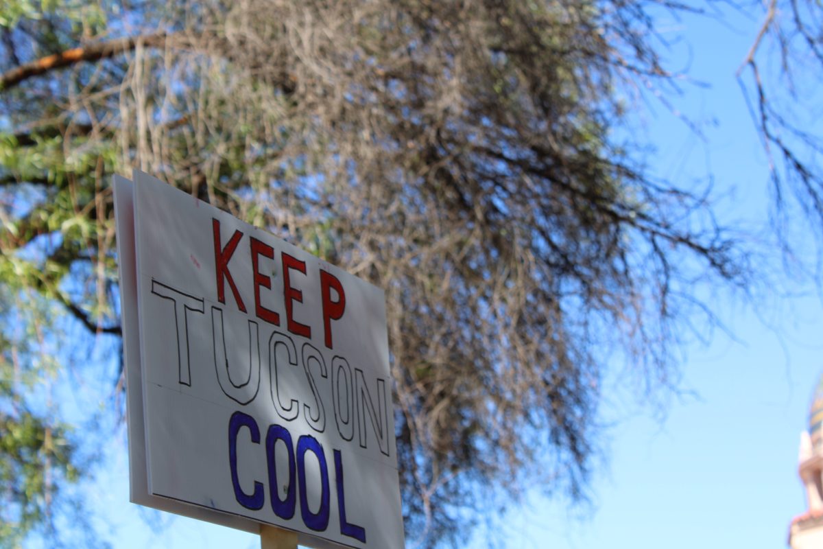 A protestor holds a sign reading Keep Tucson Cool.