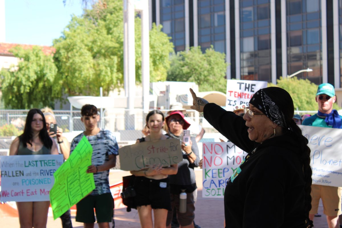 Vana Lewis speaks to a crowd of protestors holding signs.