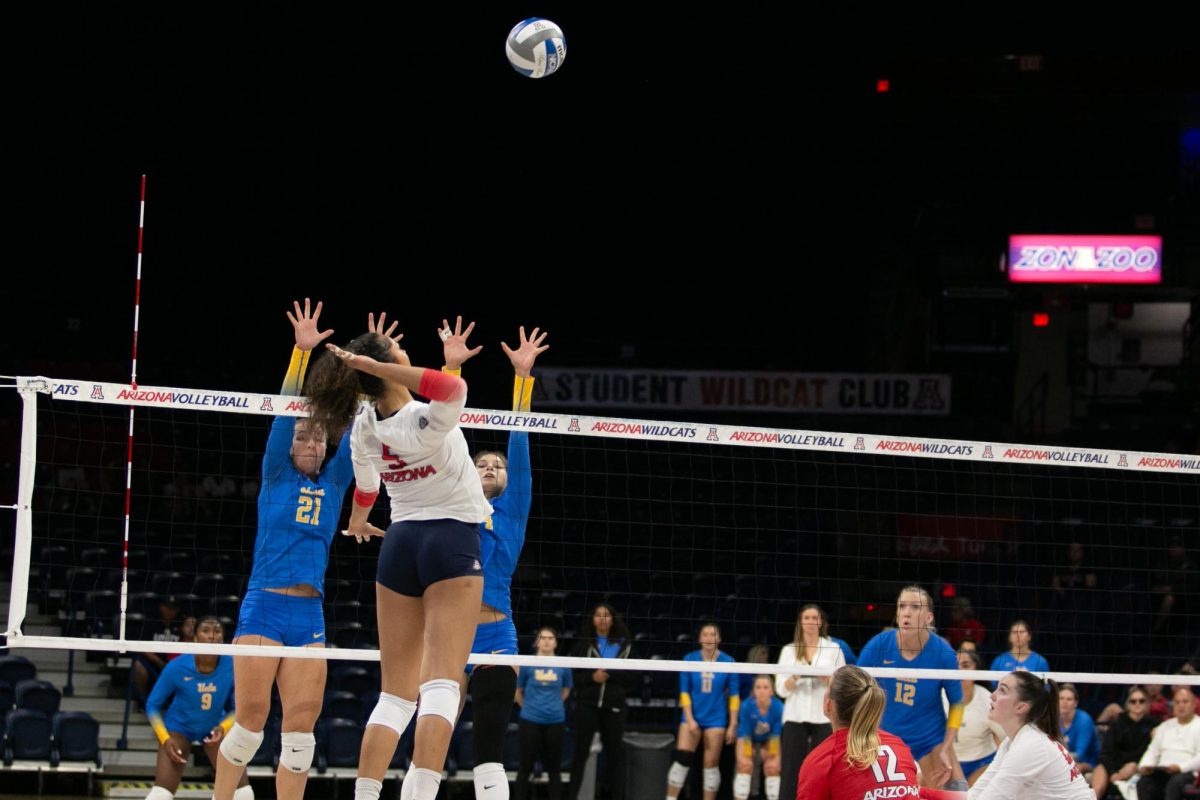 Jordan Wilson (5) of the Arizona Wildcats prepares an overhead attack against Kate Lane (21) and Brooklyn Briscoe (4) of the UCLA Bruins on Oct. 6. Wilson, a sophomore, is in her first season at the University of Arizona after her freshman year at USC. 