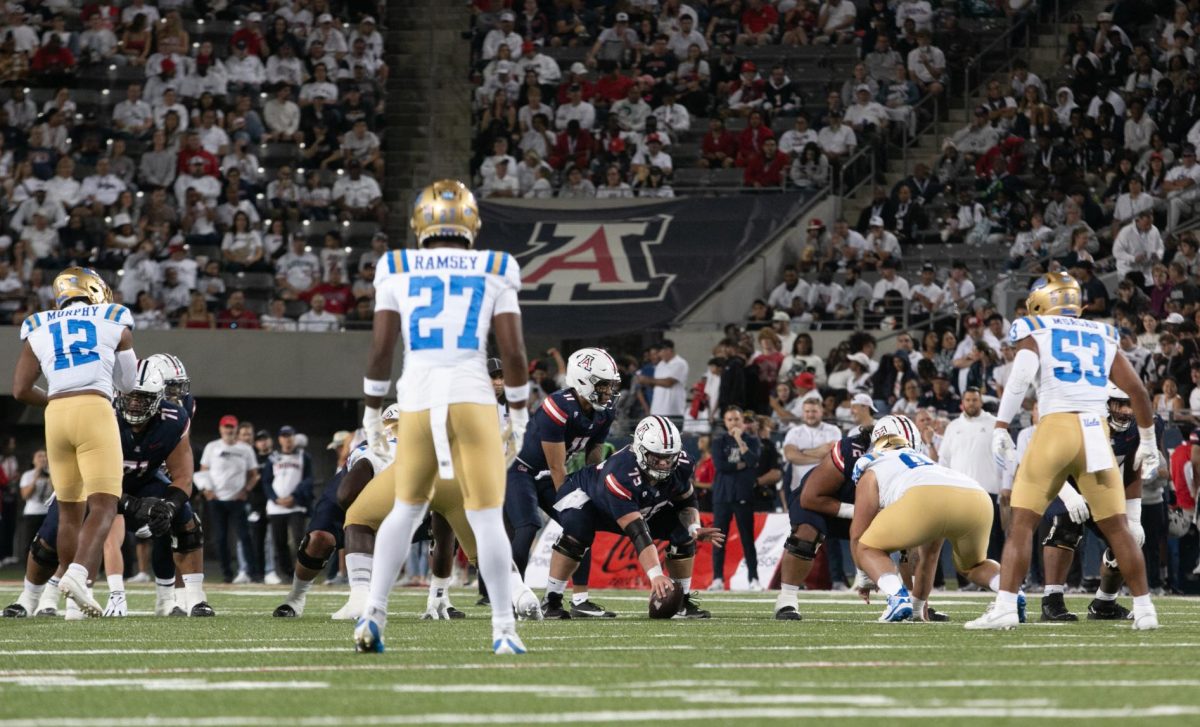 Josh Baker (75) of the Arizona football team prepares to snap the ball as UCLA prepares to mount its defense during the Homecoming football game at Arizona Stadium on Saturday, Nov. 4. The opening stages of the game saw an explosive offense from the Wildcats.