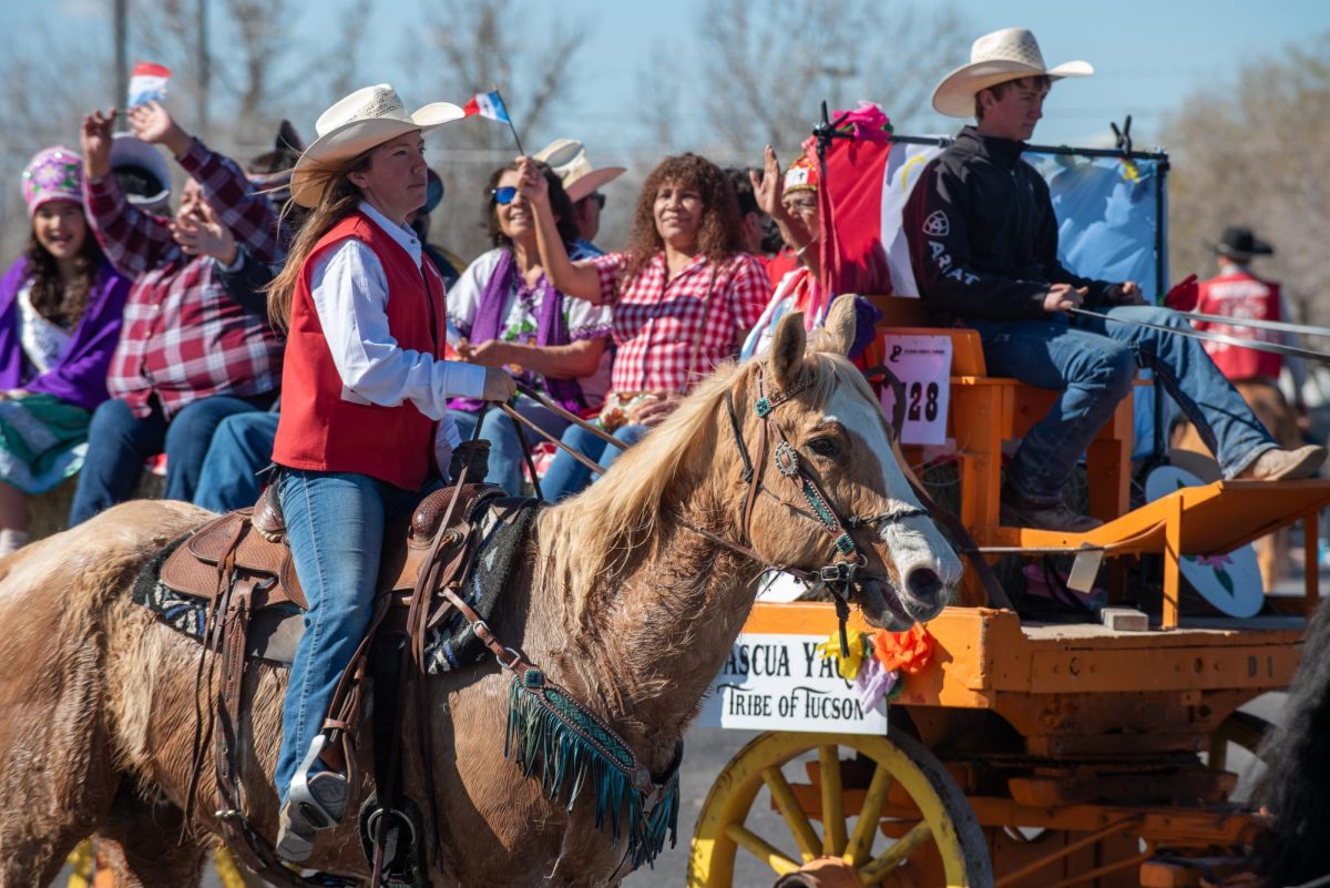 Pascua Yaqui representatives participate in the Tucson Rodeo Parade on Feb. 22. A parade marshal on a horse rides alongside them.
