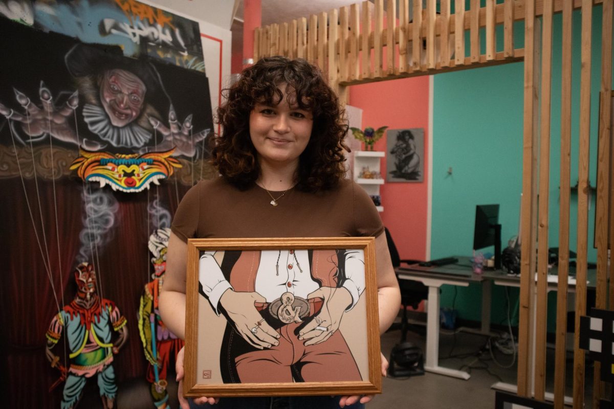 Elleanor Spencer holds up a framed print for the upcoming second anniversary event at &Gallery in Tucson on Feb. 17. This print among others will be found on display next Saturday, for the second anniversary show.
