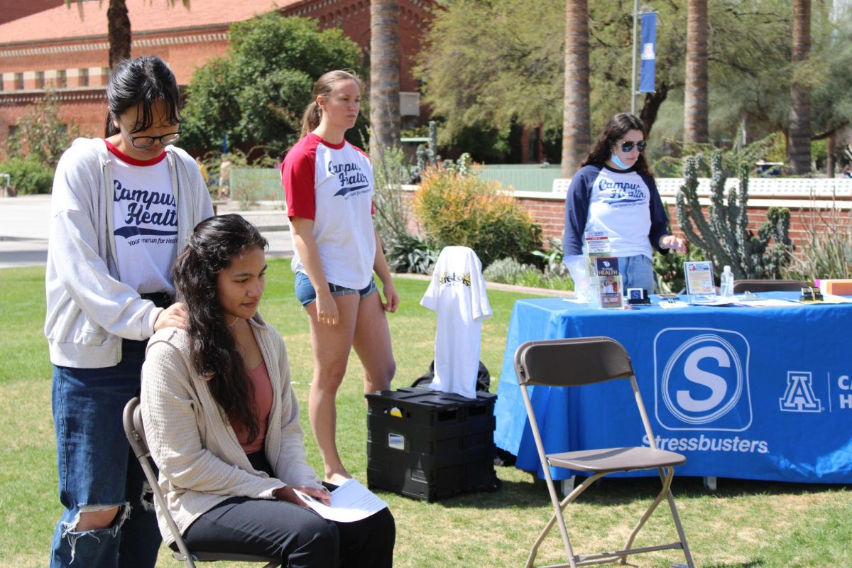 A Campus Health member gives a back massage to a student at the Self Care Fair event on the UA Mall on March 25. This was the Campus Health student boards first curated event.