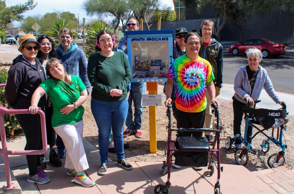 ArtWorks artists pose with the new Mini MOCA outside of the ArtWorks building on March 15. ArtWorks promotes community learning through artistic expression and interactions between adults with intellectual and developmental disabilities and University of Arizona students.