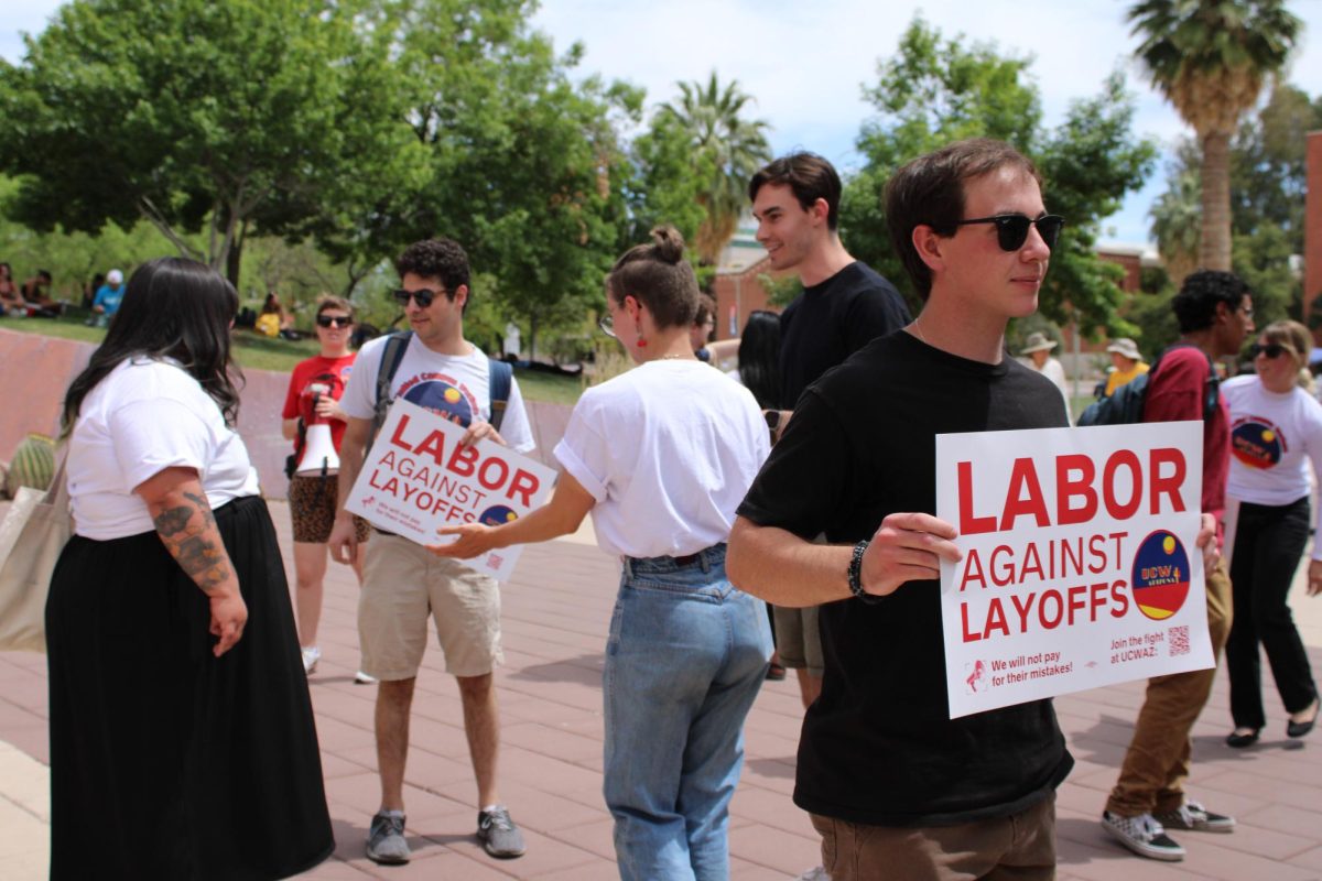 Rhys Williams holds a Labor against layoffs sign during a rally on April 18 in front of the Administration building. The rally expressed concerns of threats to higher education and campus worker jobs.