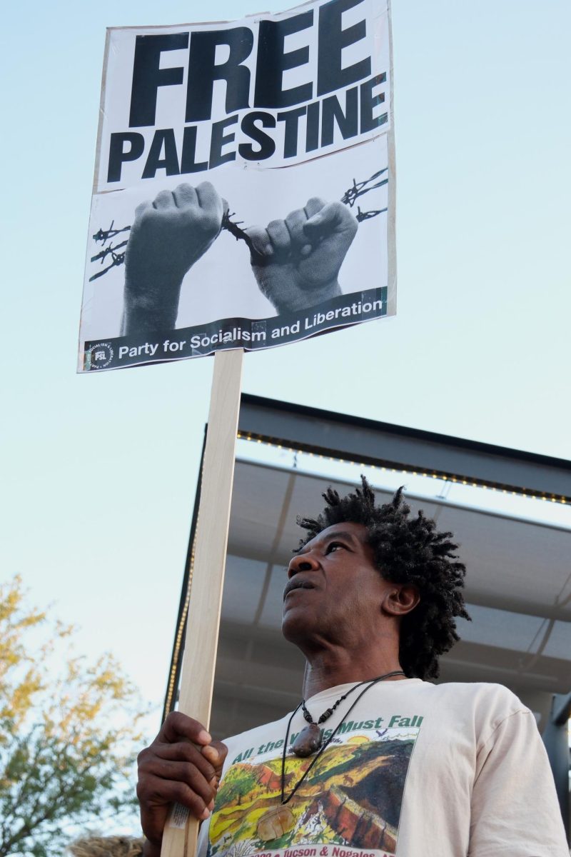 A protestor listens to chants while holding a sign on University Boulevard on Sept. 24. While in support for Lebanon, many chants included calls for Palestinian liberation.