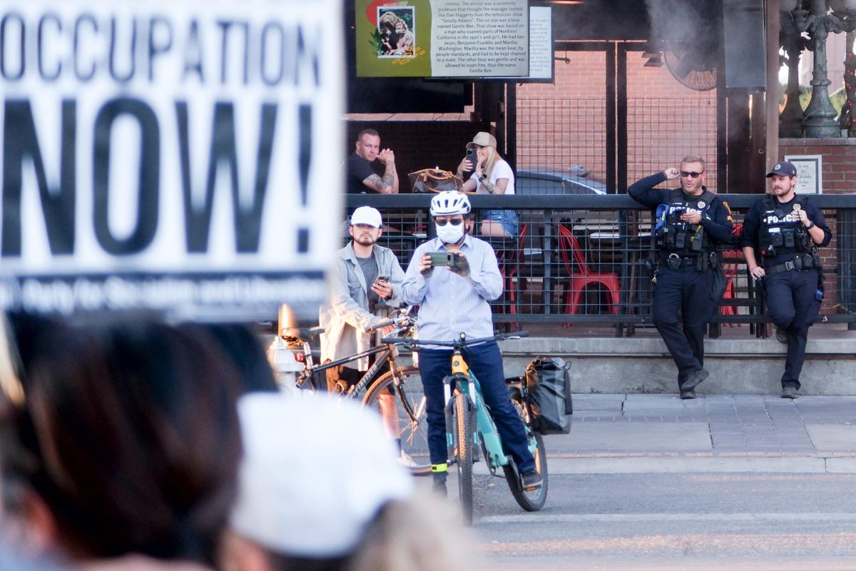 Police and spectators watch as the protest continues on University on Sept. 24. Police presence was limited with only about a dozen officers watched the protest from adjacent streets.