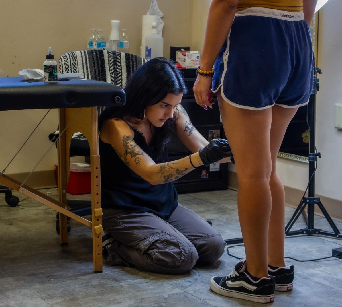 Sofia Rios applies a tattoo stencil to a client on Sept. 14 in her studio. The client was receiving a tattoo for Rios's Friday the 13th sale.