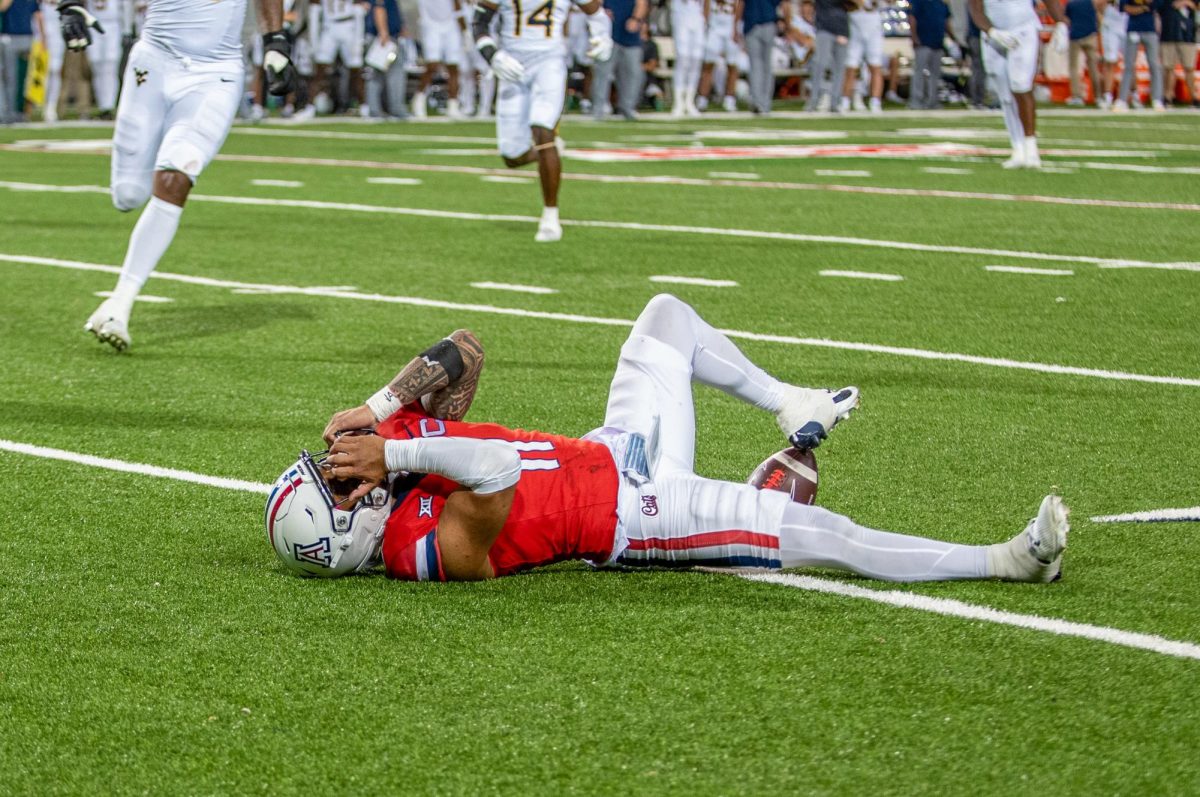 Quarterback Noah Fifita lays on his back after dropping a pass from Tetairoa McMillan on a trick play in the fourth quart on Oct. 26 at Arizona Stadium. Arizona lost the game 31-26 to the University of West Virginia. With the loss the Wildcats now drops them to 3-5 on the season. 