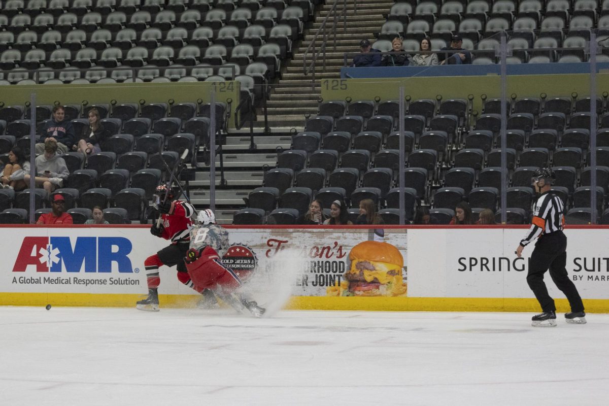 University of Arizona Wildcat hockey player, Jack Kurrrle (8), fights for the puck against UNLV on Oct. 24 at Tucson Convention Center. 