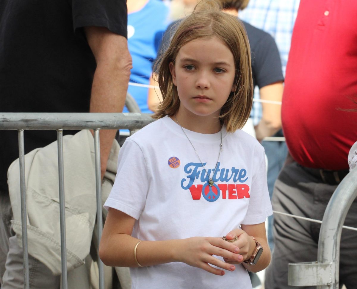 A young child stands in line at the Obama rally on Oct. 18 at the Cole and Jeannie Davis sports center. They wear a shirt saying "Future Voter."