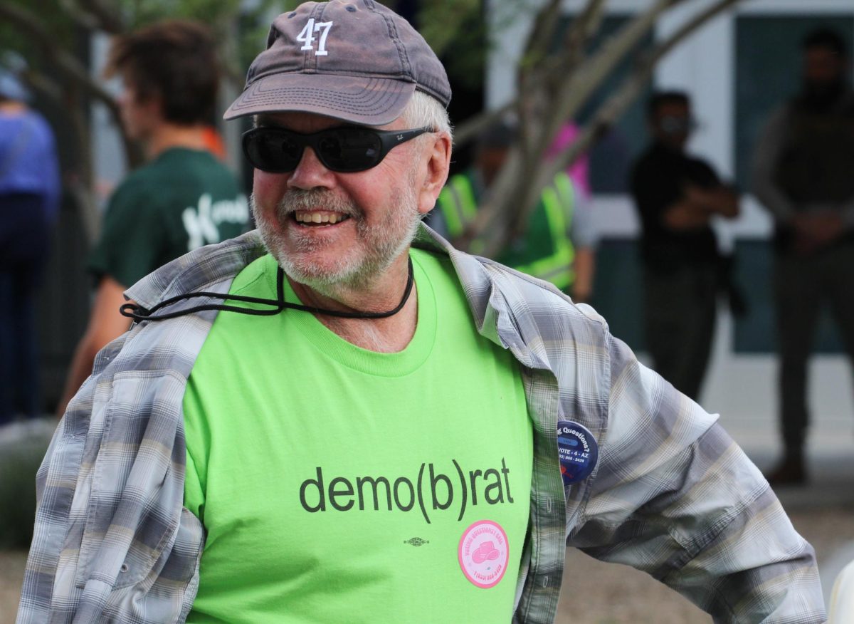 A man wears a shirt with the words "demo(b)rat" at Obamas get-out-the-vote rally at Cole and Jeannie Davis sports center on Oct. 18. Obama encourages people to vote early for Vice President Kamala Harris and Governor Tim Walz. 