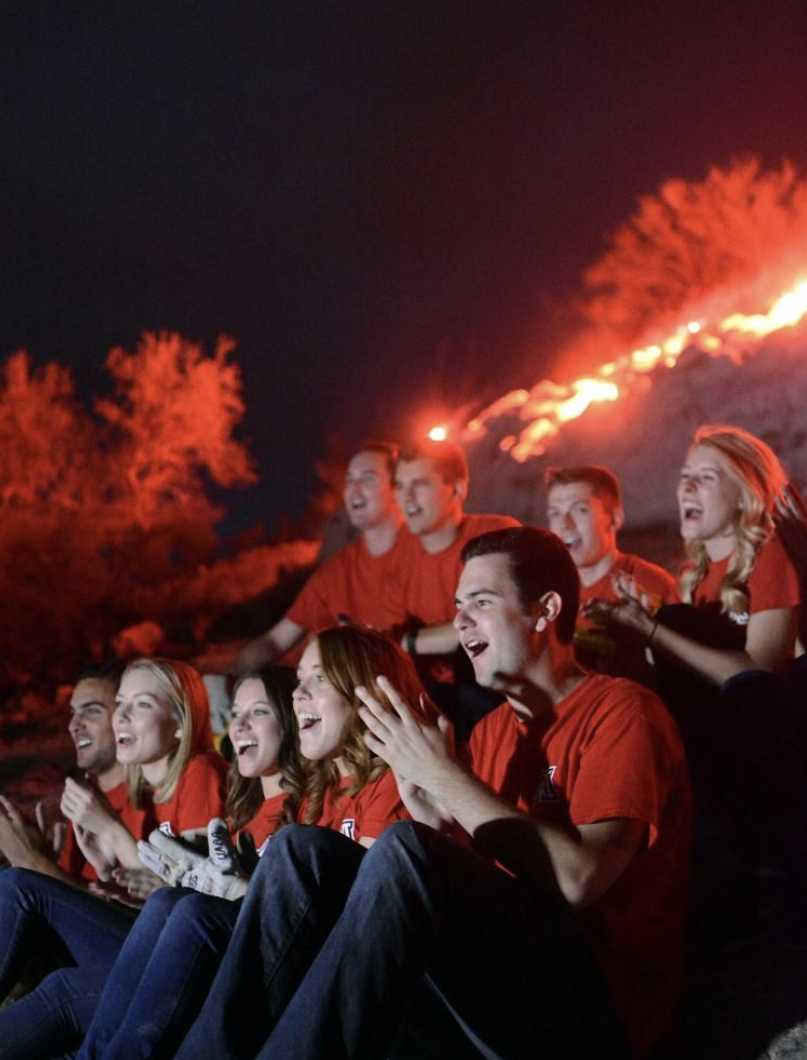 The Bobcats senior honorary claps while singing "Bear Down Arizona," the UA fight song, after lighting the "A" on "A" Mountain with flares during the annual ceremony on Sunday, Oct. 23, 2016.