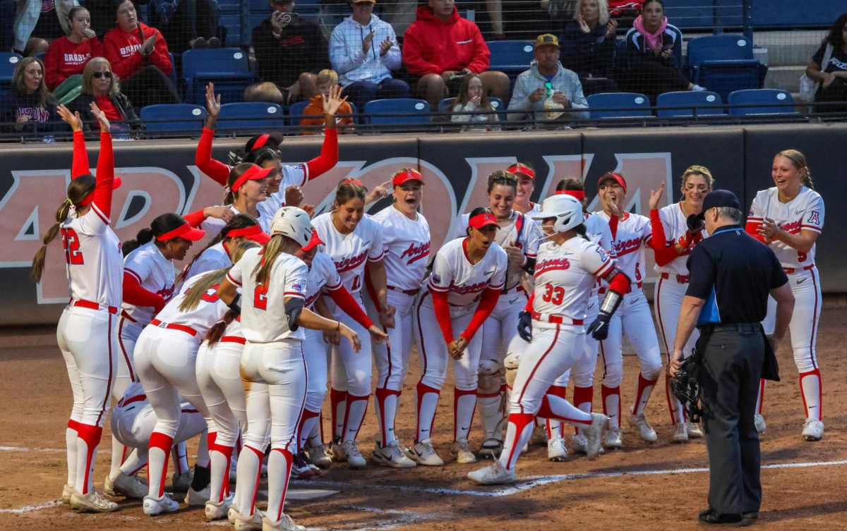 The Arizona softball team cheer on Jenna Sniffen at home plate at Hillenbrand Stadium on Oct. 18. UA's sweeping win starts off their fall season strong.