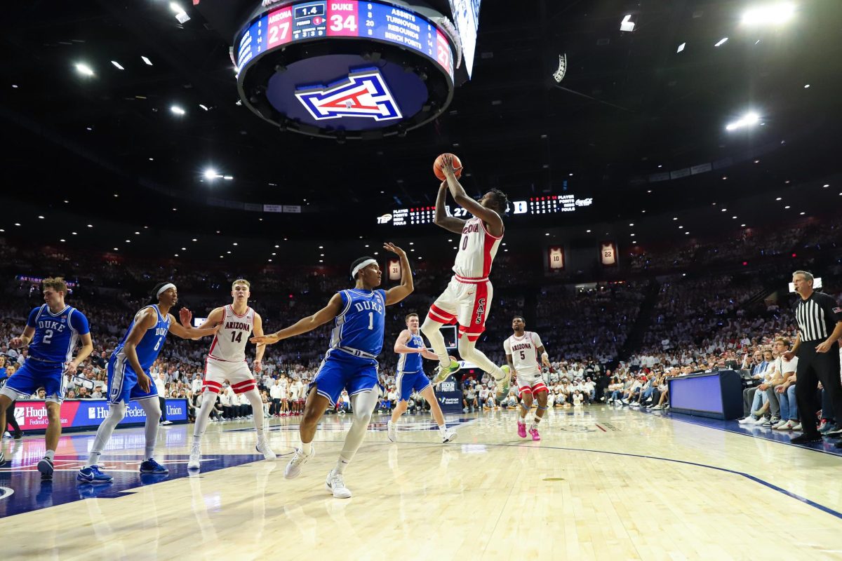 University of Arizona mens basketball player Jaden Bradley shoots an awkward jumper over a defender in Arizona's home matchup against Duke on Nov. 22 in McKale Center. Bradley lead the team with 18 points.