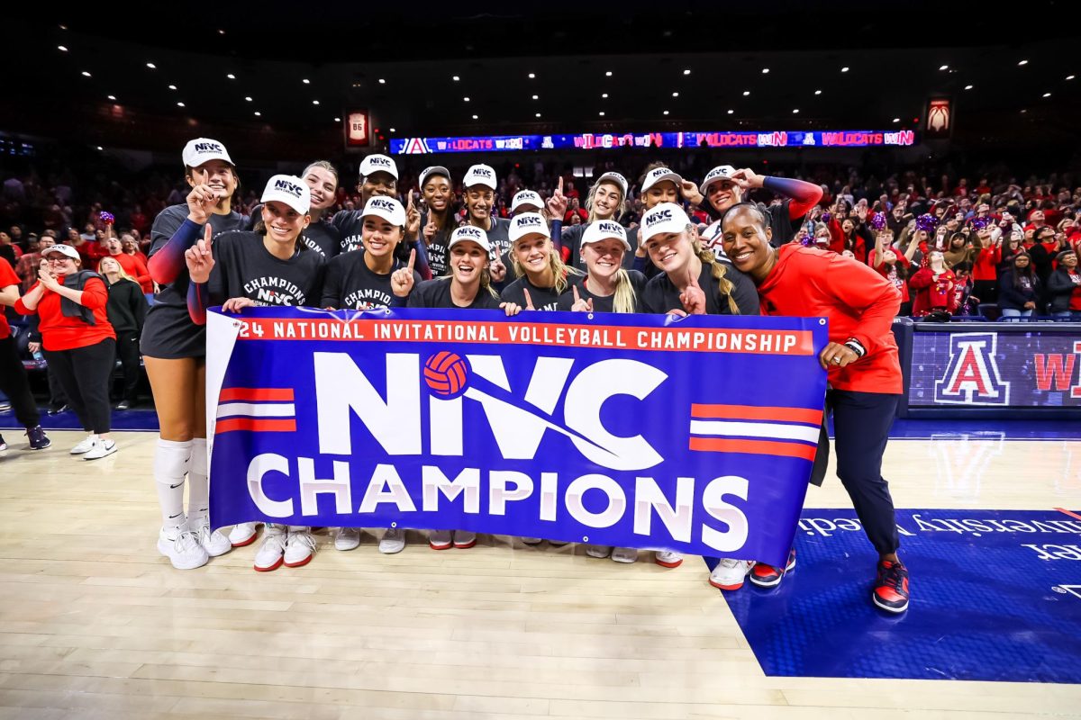 University of Arizona's volleyball team poses in front of NIVC Championship banner on Dec. 17 in McKale Center. 