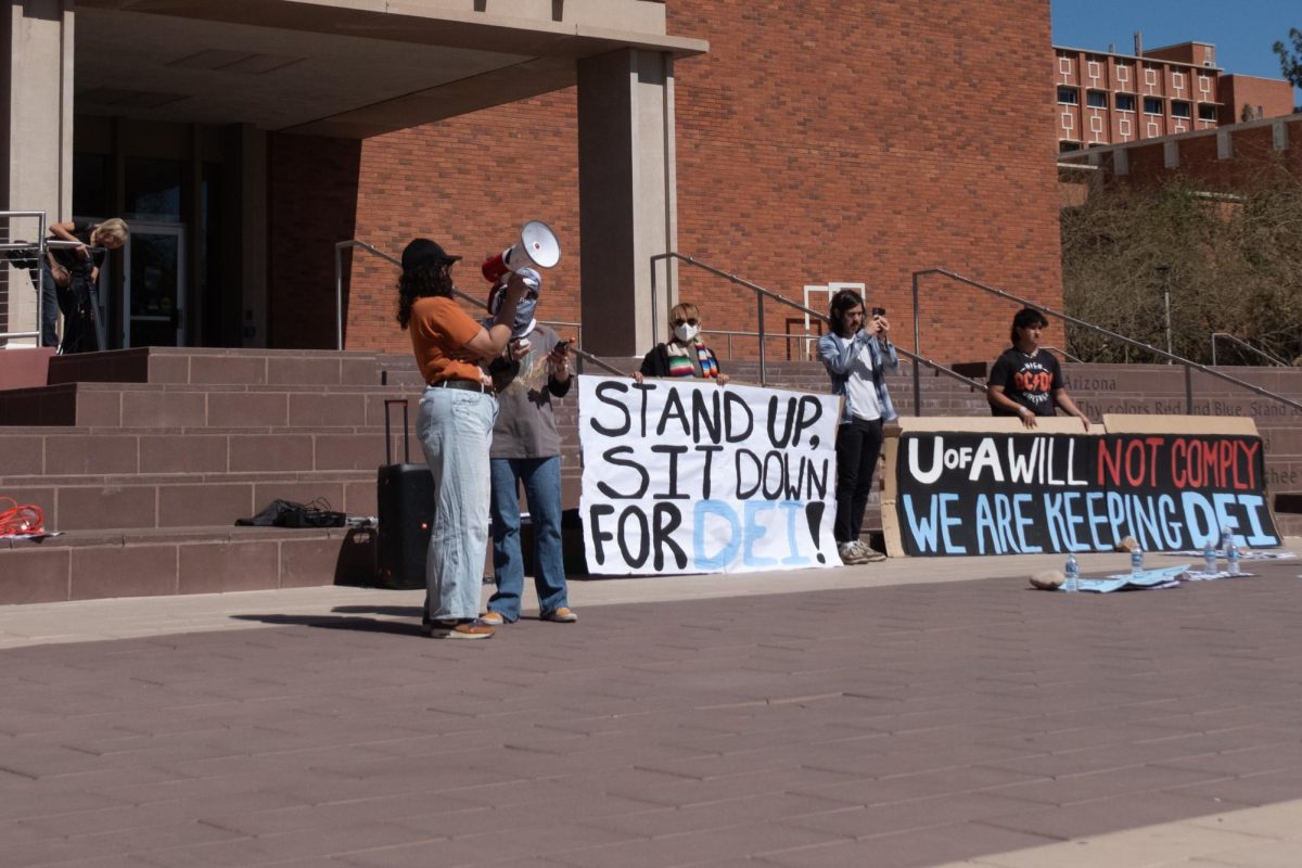 Protest leaders switch out during a protest at campus administration on Feb. 27. Behind them, other protesters hold signs supporting D.E.I measures on campus.