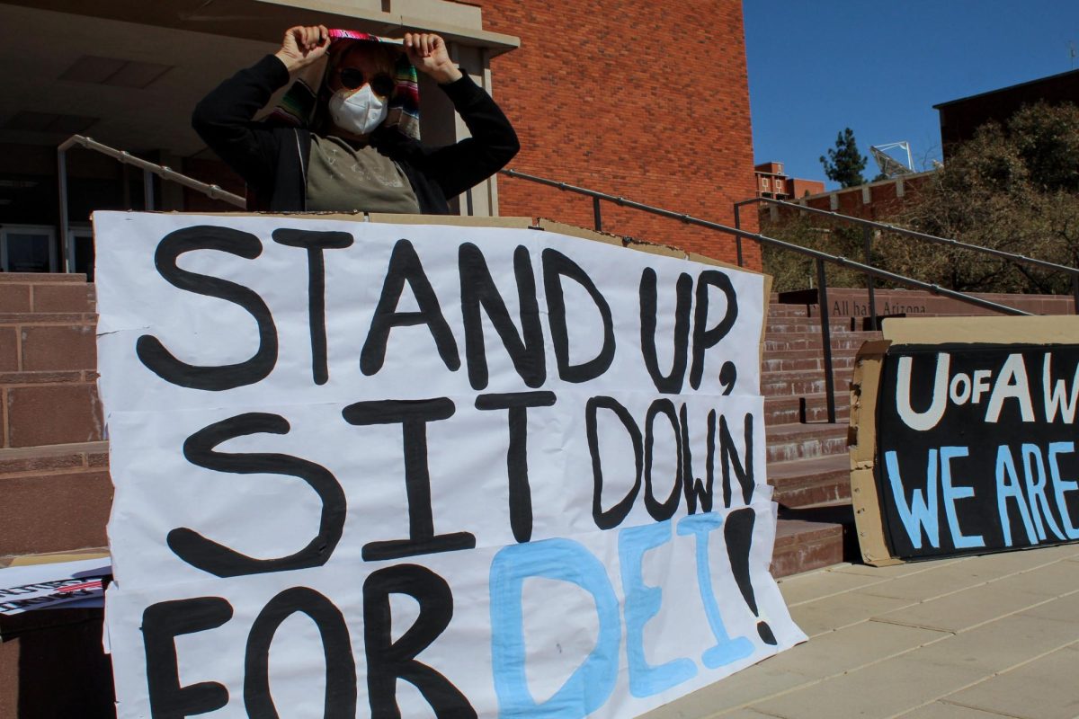 A protester props up a sign that reads “Stand Up, Sit Down For DEI” in front of the administration building on Feb. 27. The students of the U of A were protesting against the changes of DEI policy at the university.