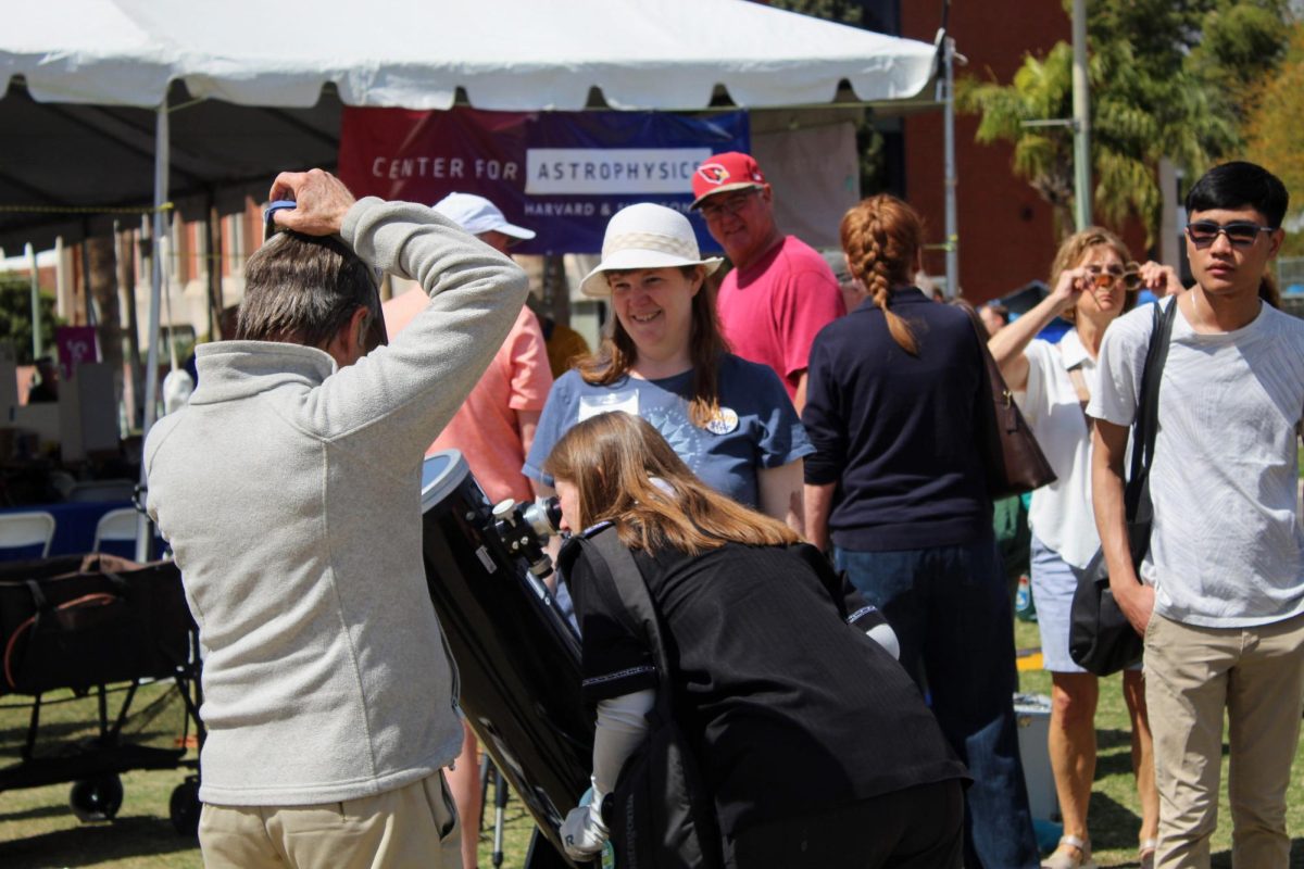 People line up to look through the telescope by the Center for Astrophysics tent at the
Tucson Festival of Books at the University of Arizona Mall on March 16. People could
experience all types of scientific activities during the festival.