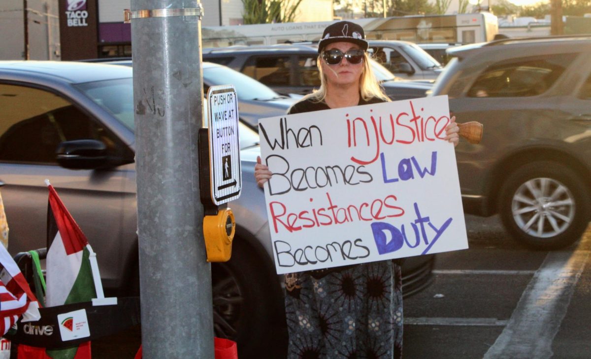 Woman standing by the crosswalk holding up a sign by the Aloft Tucson University, located at 1900 E Speedway Blvd, on Sept. 12. This protest was going against ICE but as well as the hotel Marriott, to pressure them to promise not to partner up with them for migrant detention.  

