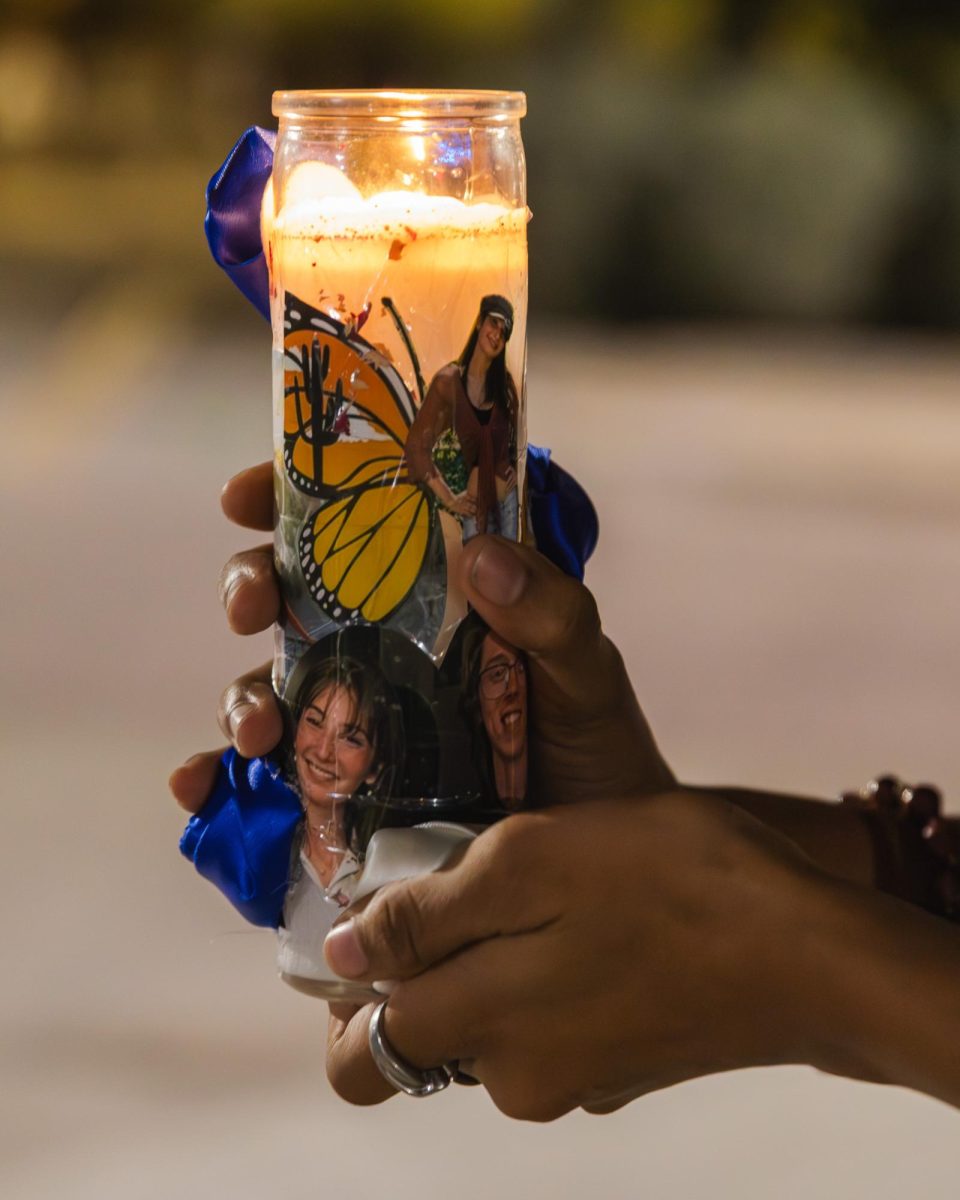 A member of the community holds a candle honoring the victims of the accident on Second Street and Euclid Avenue during a memorial service on Nov. 2 at the site of the accident.