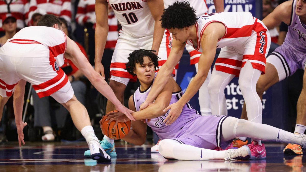 Brayden Burries and Ivan Kharchenkov fight a Kansas State player for the ball in McKale Center on Jan. 7.