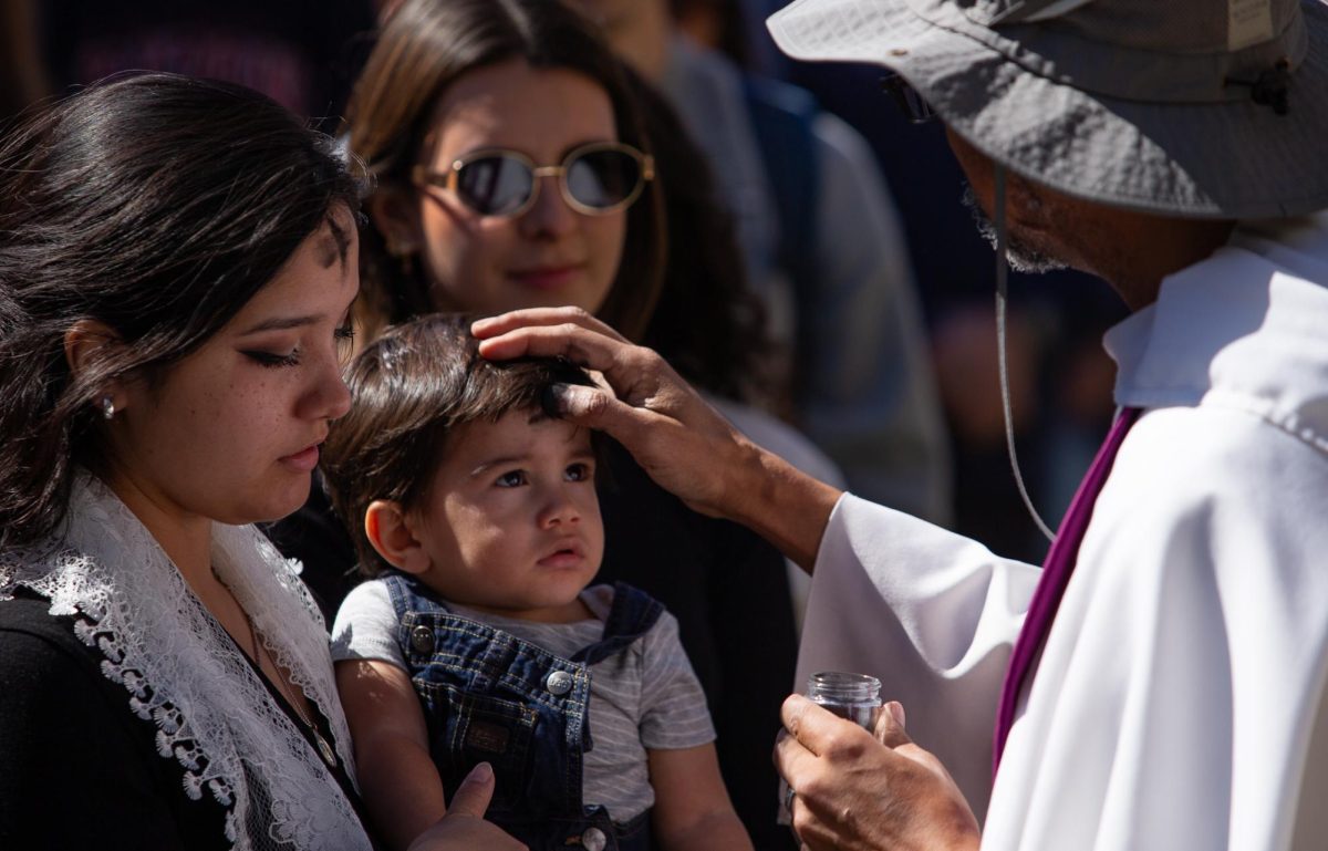 A mother and her son get ashes applied to their foreheads for Ash Wednesday on Feb. 18.